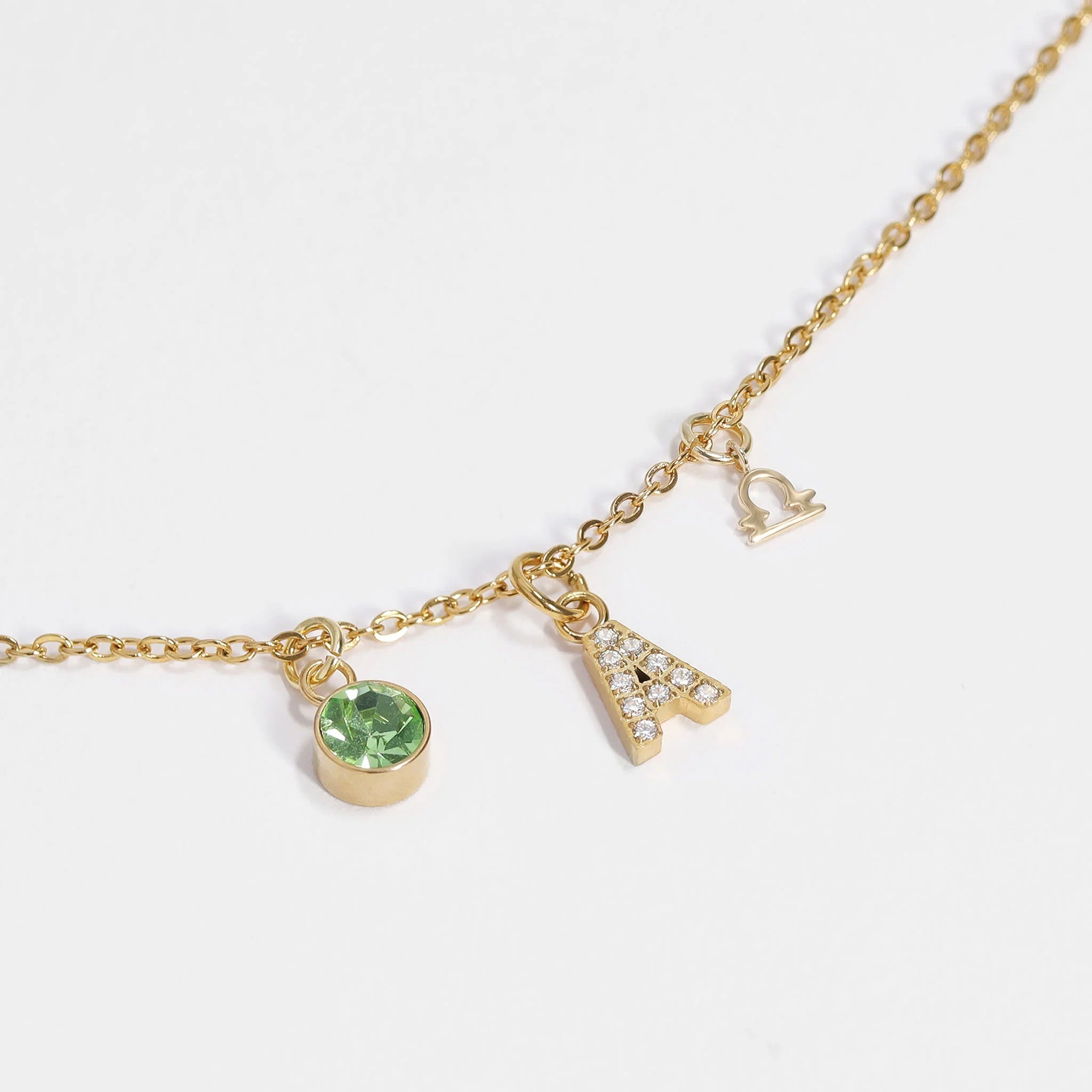 gold stainless steel birthstone charm necklace with green birthstone and zodiac pendant charms