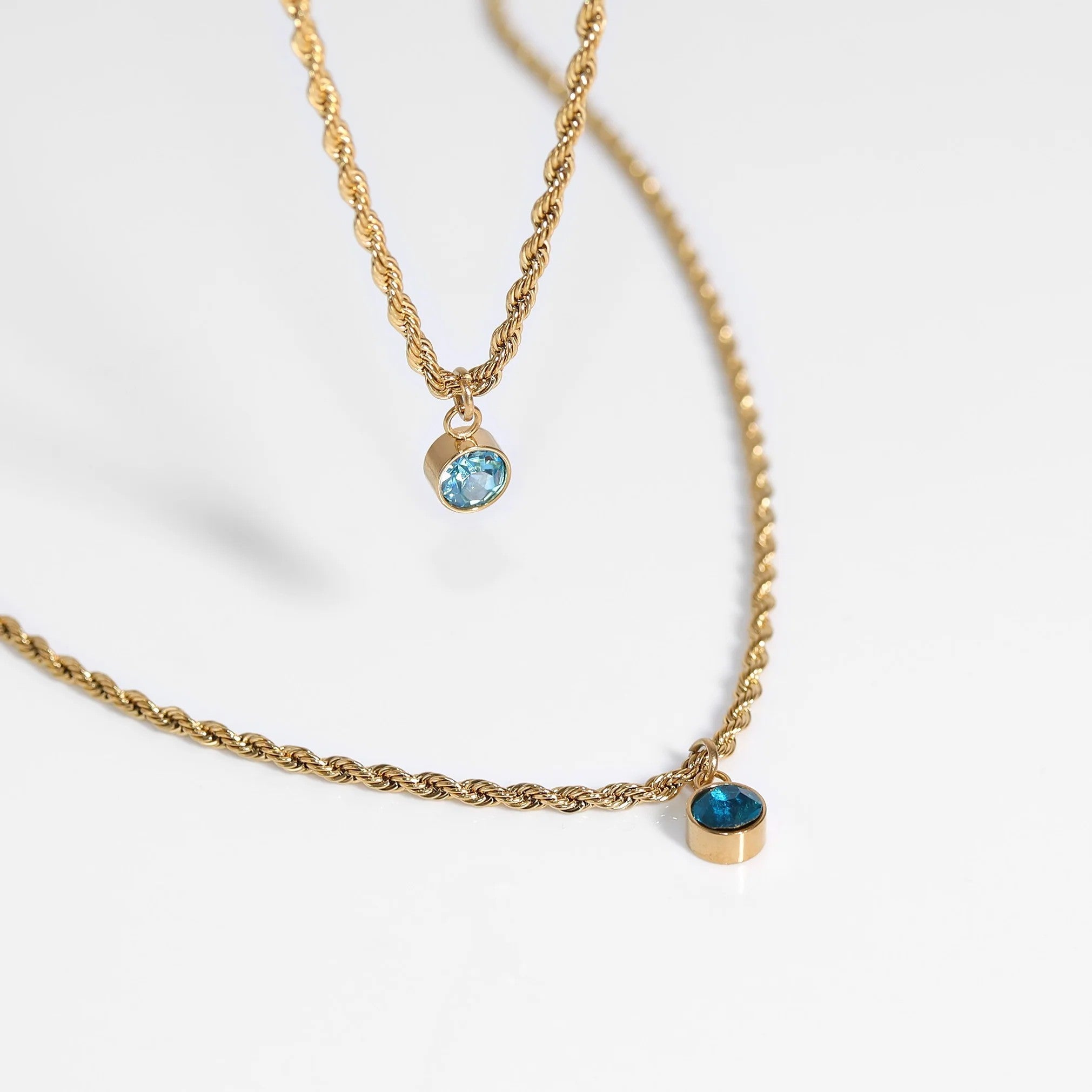Gold stainless steel birthstone charm necklace with blue gemstones by Melchior Jewellery