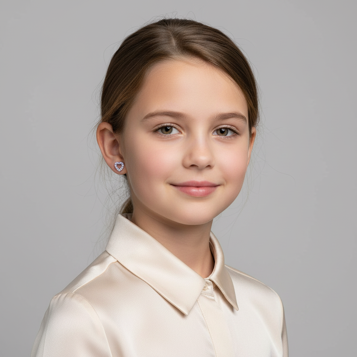 Melchior Jewellery sterling silver heart earrings for girls worn by smiling child with satin blouse