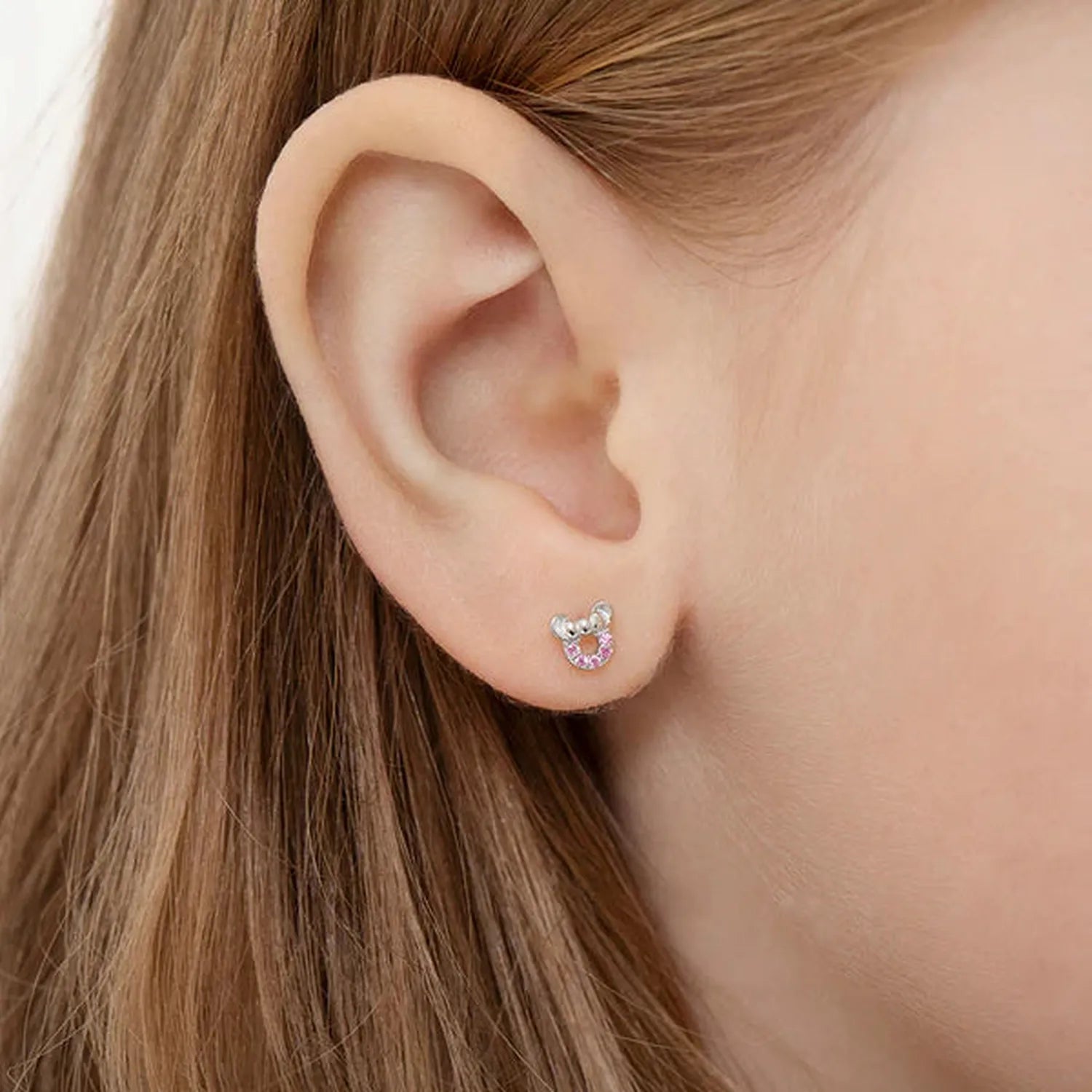 Delicate silver girls mouse earrings with pink crystal detail worn on ear by young girl