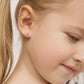 In Season Jewellery pink gemstone studs on a smiling child showcasing girls screw back earrings for safety