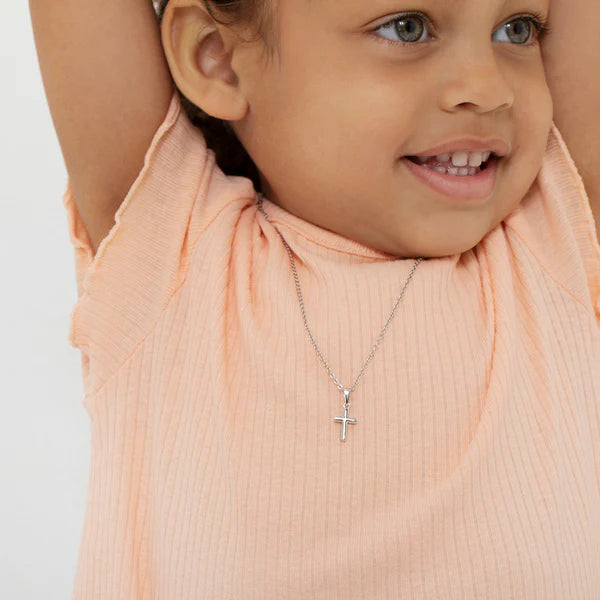 Girls sterling silver cross necklace and earrings worn by smiling girl in peach top from Melchior Jewellery