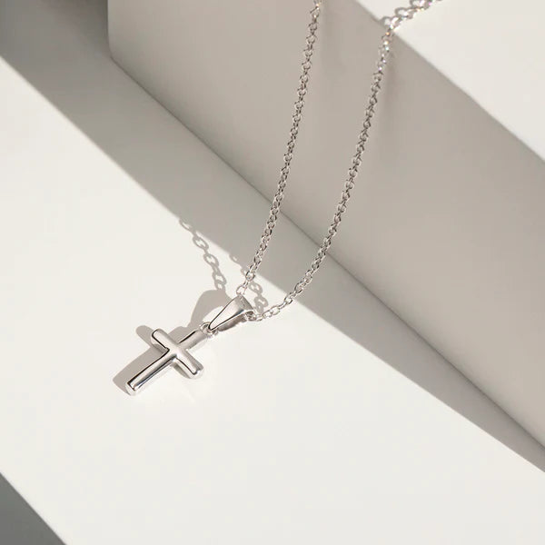 Girls sterling silver cross necklace and earrings from Melchior Jewellery displayed on white background