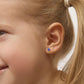 Close-up of a child wearing kids gold earrings with sapphire stone from In Season Jewellery
