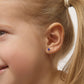 Child wearing 14k gold February birthstone earrings from In Season Jewellery with small purple gemstones