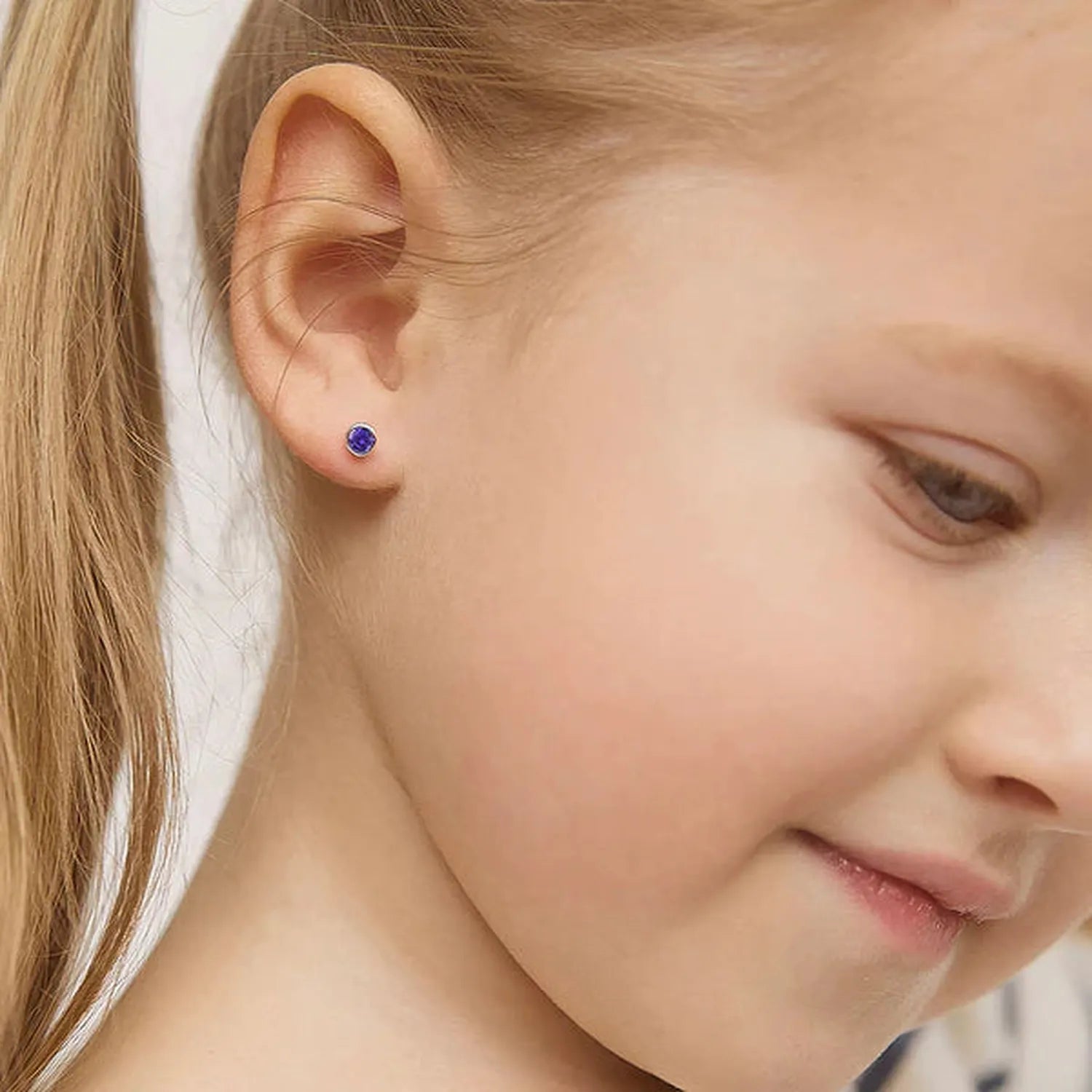 4mm silver screw back earrings with purple stones worn by a young girl from In Season Jewellery