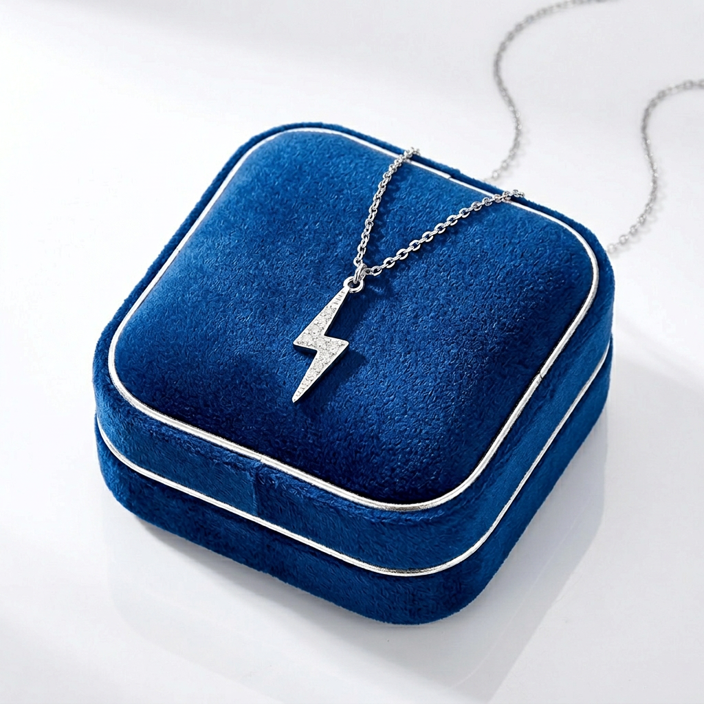 Sterling silver lightning necklace with sparkling stones on a delicate chain displayed on a deep blue velvet jewellery box