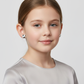 Child wearing 925 silver football stud earrings for kids by Melchior Jewellery in black and white design