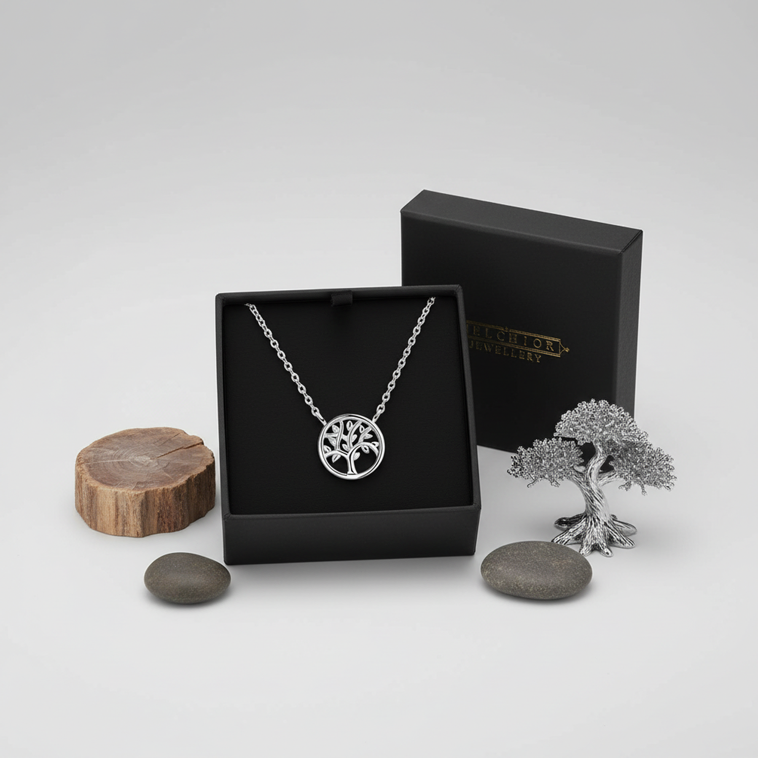 925 sterling silver tree of life necklace by Melchior Jewellery displayed in black box with decorative stones and tree figurine