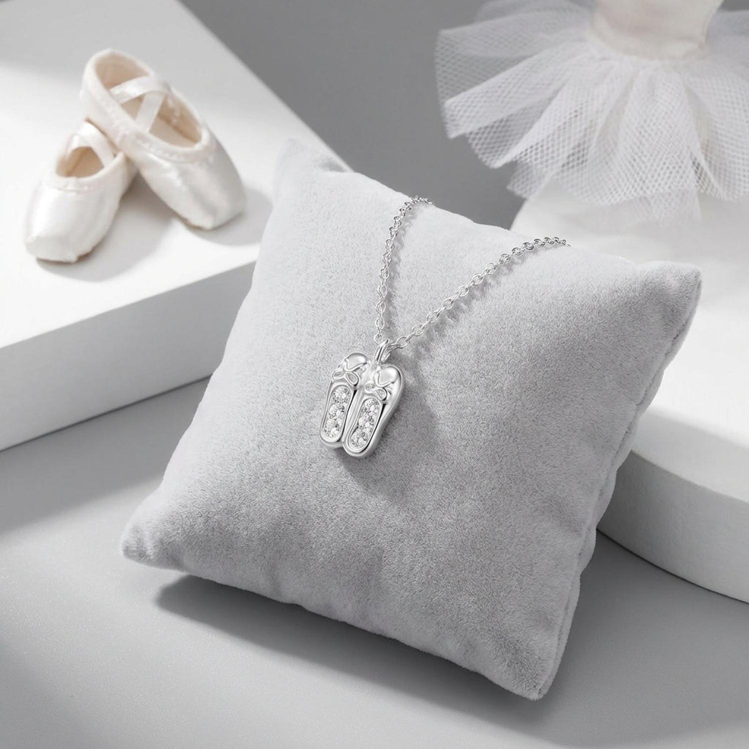 Melchior Jewellery ballet shoes charm necklace for children displayed on a soft grey cushion