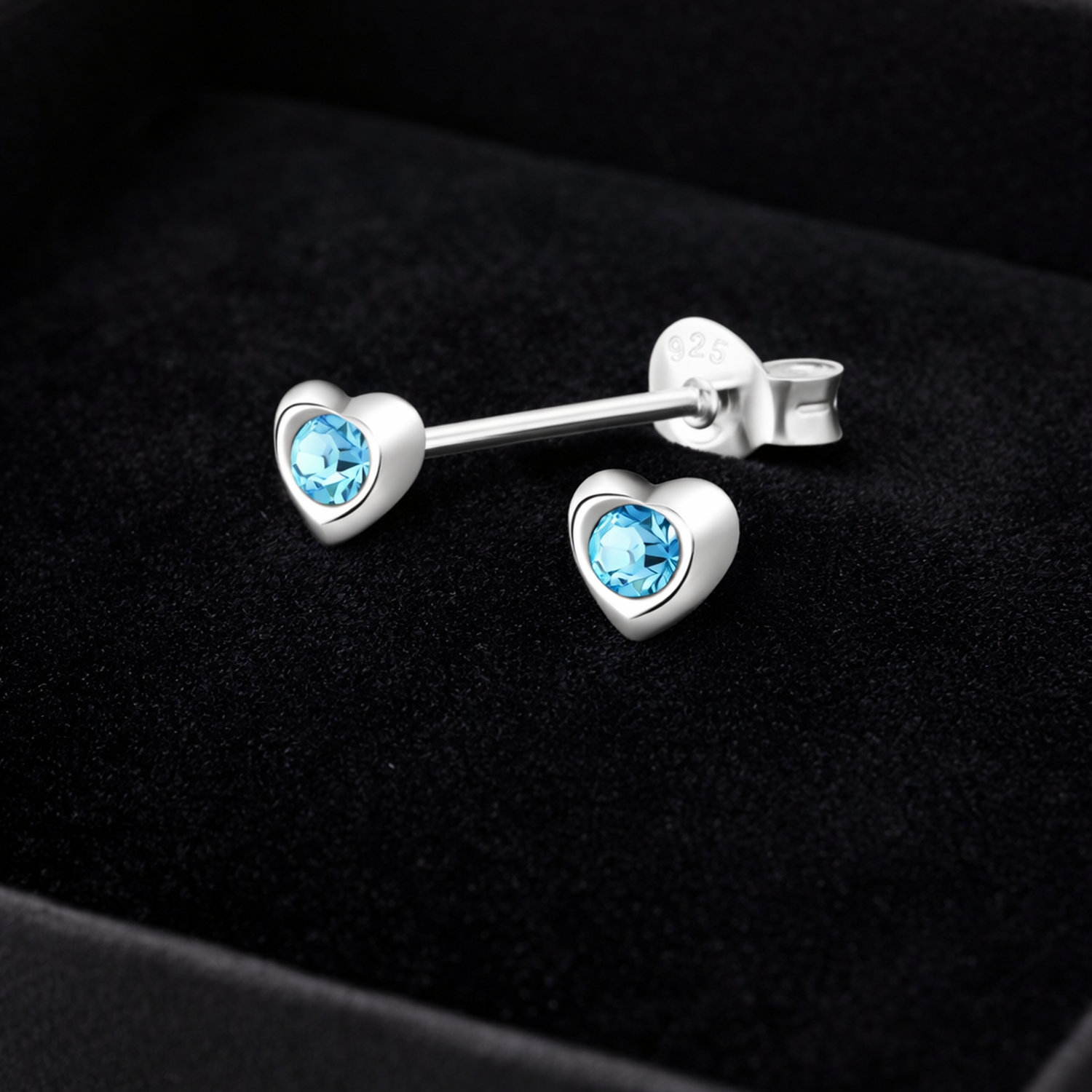 Melchior Jewellery blue crystal heart stud earrings for kids in sterling silver on black velvet