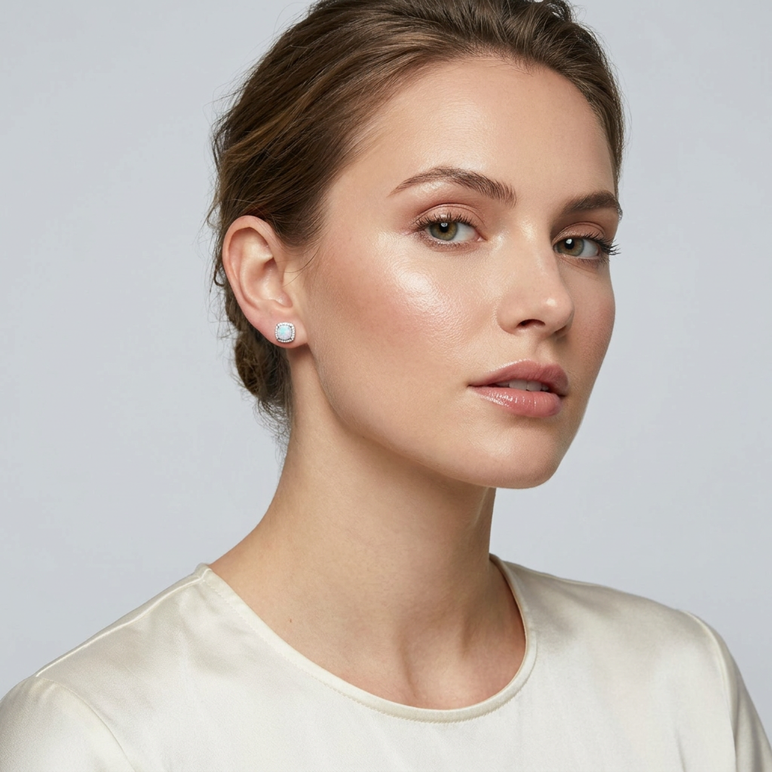 Melchior Jewellery bridal opal stud earrings with delicate milky white opals set in silver on a woman wearing a cream satin top