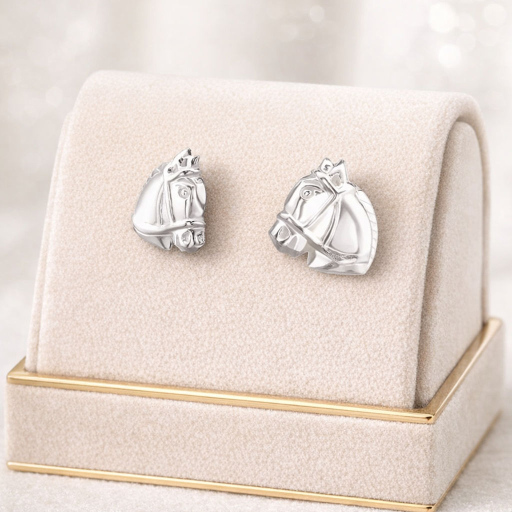 Childrens Sterling Silver Horse Stud Earrings by Melchior Jewellery displayed on soft beige velvet stand with gold trim