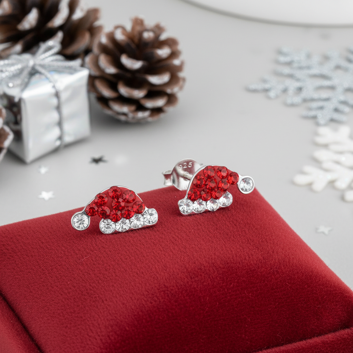 Melchior Jewellery Christmas Hat Earrings with red and clear crystals on silver studs displayed on red velvet cushion