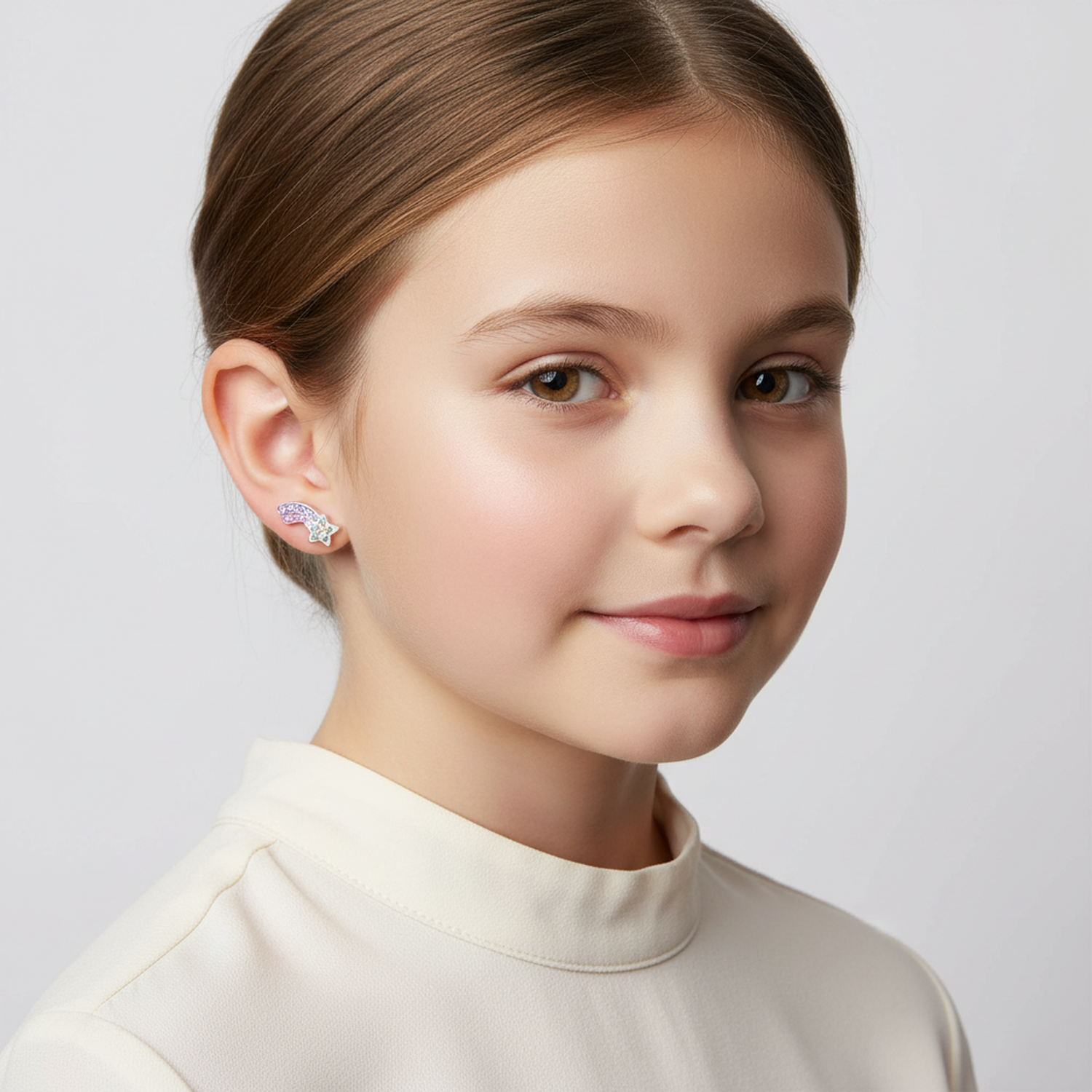 Young girl wearing colourful crystal star stud earrings for kids in pink and blue tones by Melchior Jewellery
