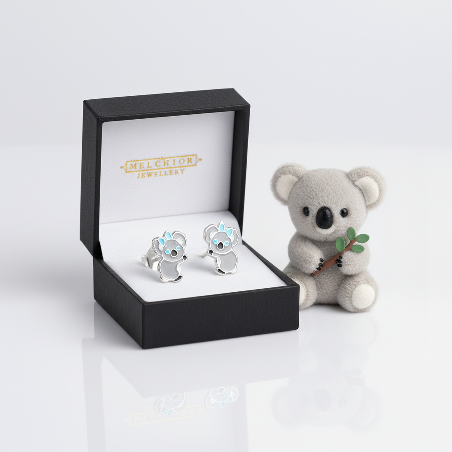 Cute koala earrings for girls by Melchior Jewellery displayed in a black gift box with a small koala plush
