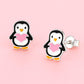 Cute penguin stud earrings for kids by Melchior Jewellery featuring black and white penguins holding pink hearts