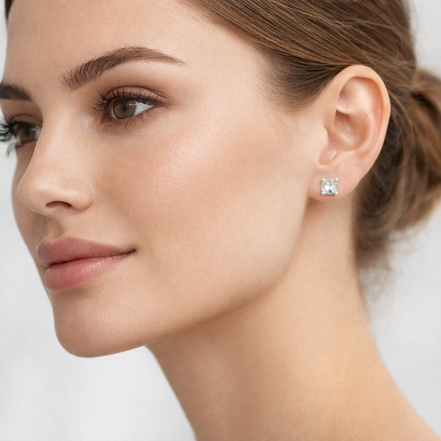 Close-up of woman wearing Melchior Jewellery CZ square 4mm stud earrings with clear sparkling stones