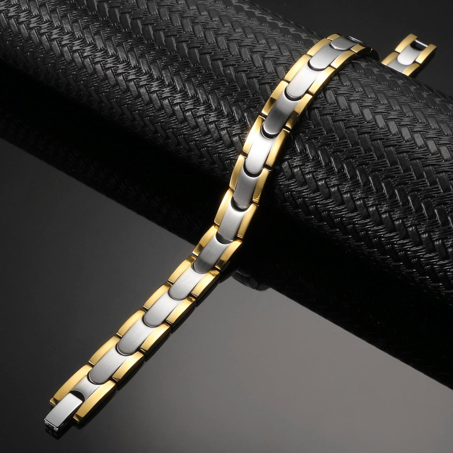 Melchior Jewellery dual-tone magnetic bracelet with gold and silver links on black textured display
