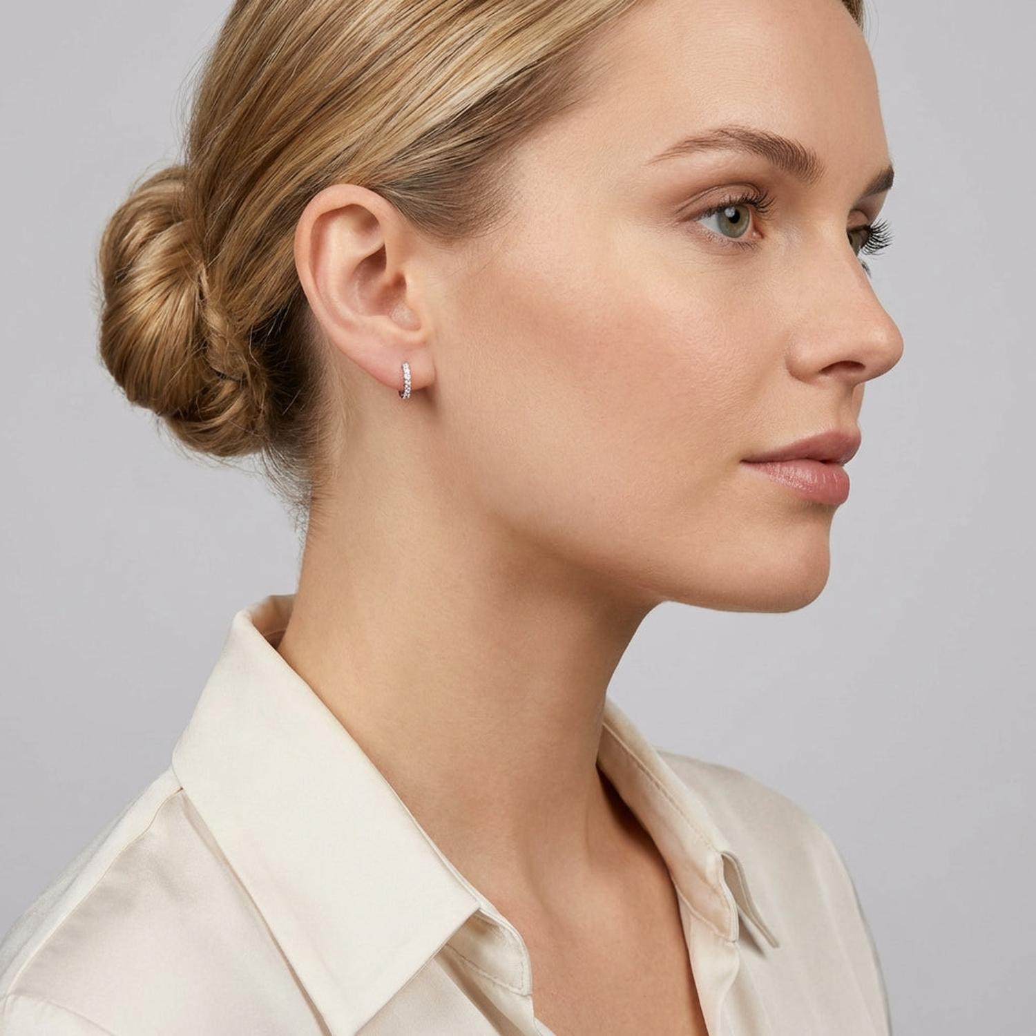 Elegant silver half hoop earrings for gifts worn by woman with blonde hair in neat bun from Melchior Jewellery