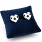 Melchior Jewellery football earrings for girls shaped like black and white heart footballs on navy cushion