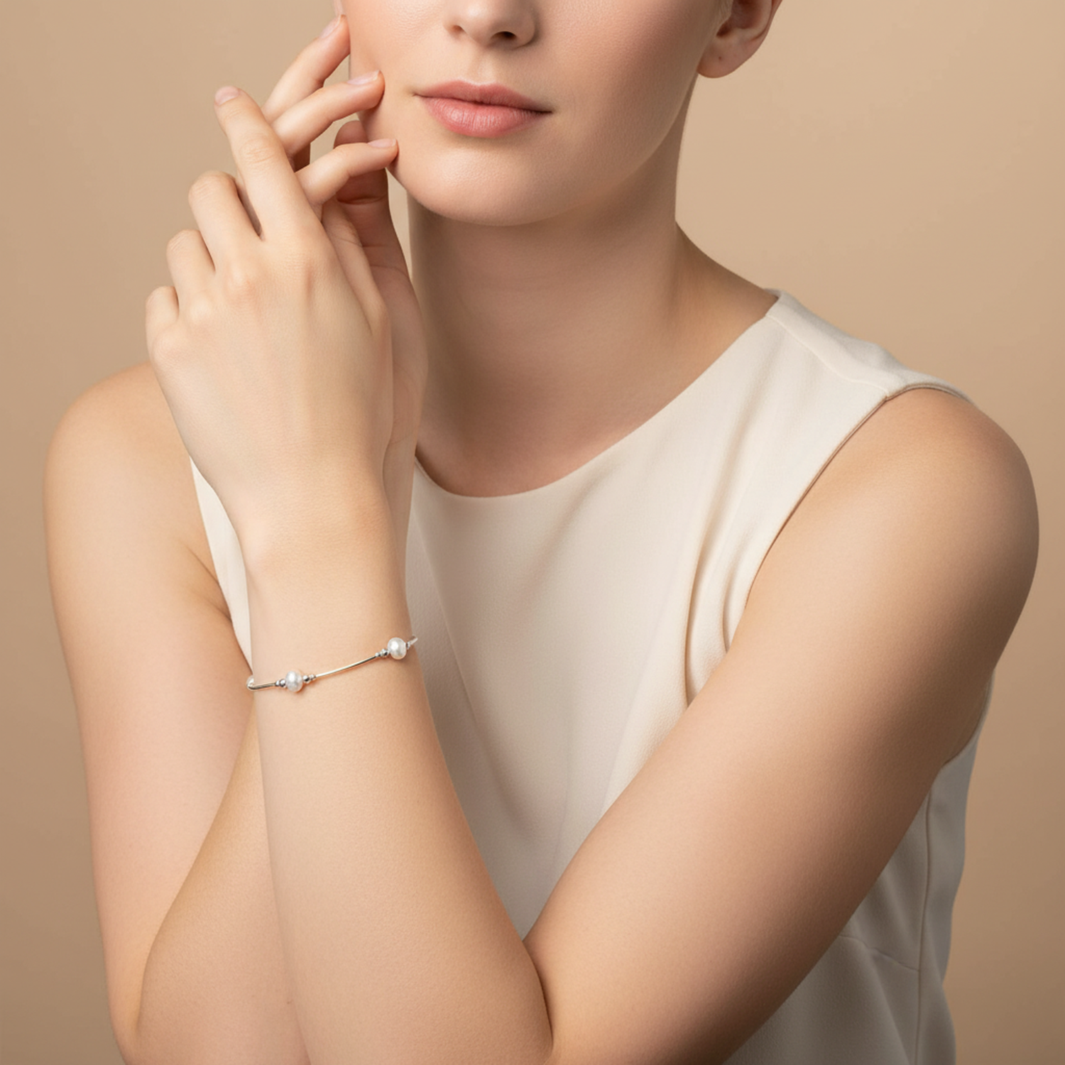 Elegant Melchior Jewellery freshwater pearl beaded bracelet worn on womans wrist with cream sleeveless top