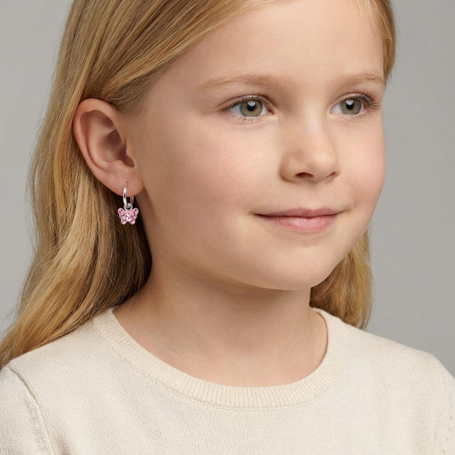 Girls butterfly earrings sterling silver with pink enamel detail worn by a young girl from Melchior Jewellery