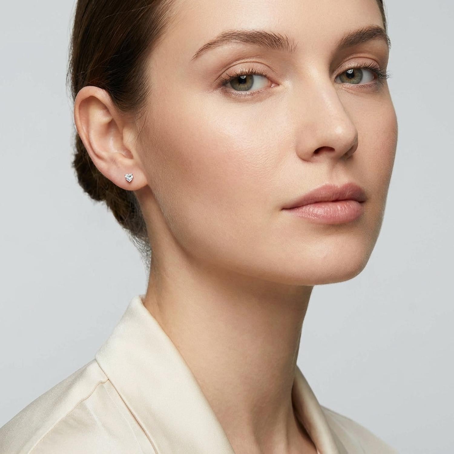 Melchior Jewellery Icon Heart Stud Earrings worn by woman with a neutral expression and cream blouse