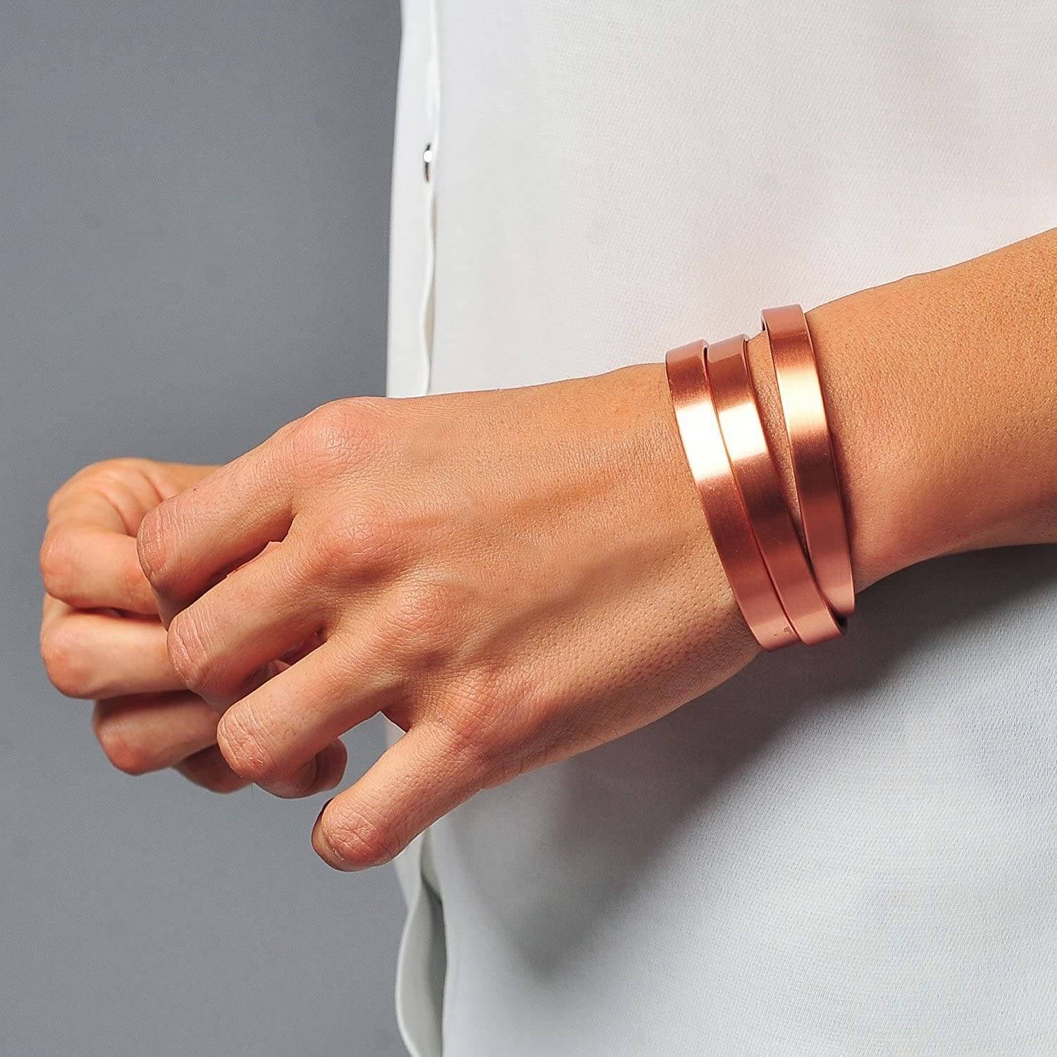 Melchior Jewellery magnetic copper therapy bangle trio of smooth polished copper cuffs worn on a model wrist