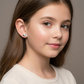 Young girl wearing Melchior Jewellery kids football boot stud earrings in silver, perfect for children