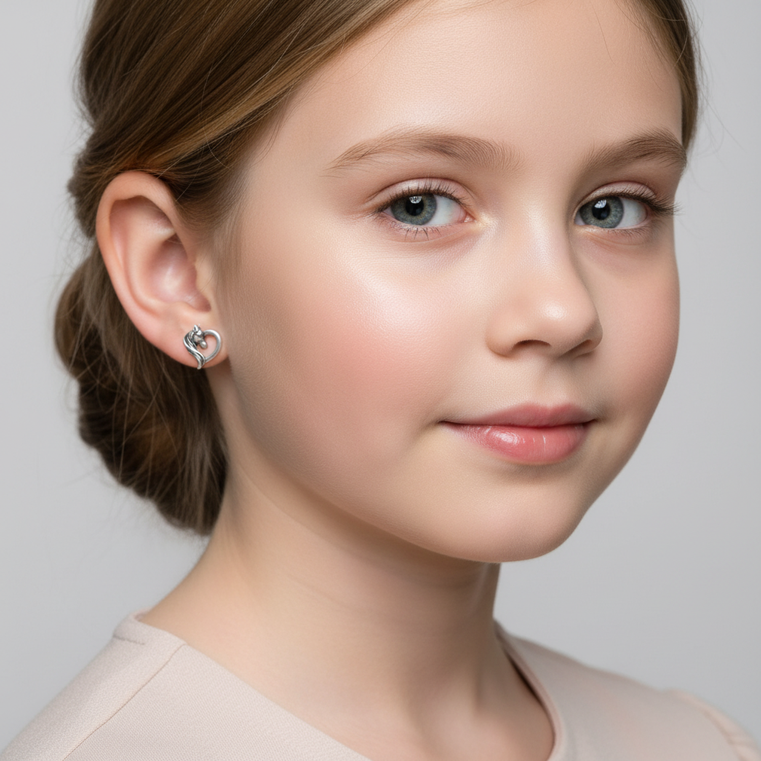 Melchior Jewellery kids heart shaped horse stud earrings worn by young girl in close-up portrait