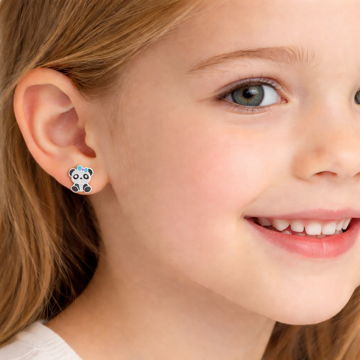 Melchior Jewellery kids hypoallergenic panda stud earrings worn by a smiling child with blue eyes and blonde hair