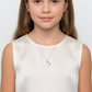 Melchior Jewellery kids unicorn pendant silver necklace worn by child with long hair and white top