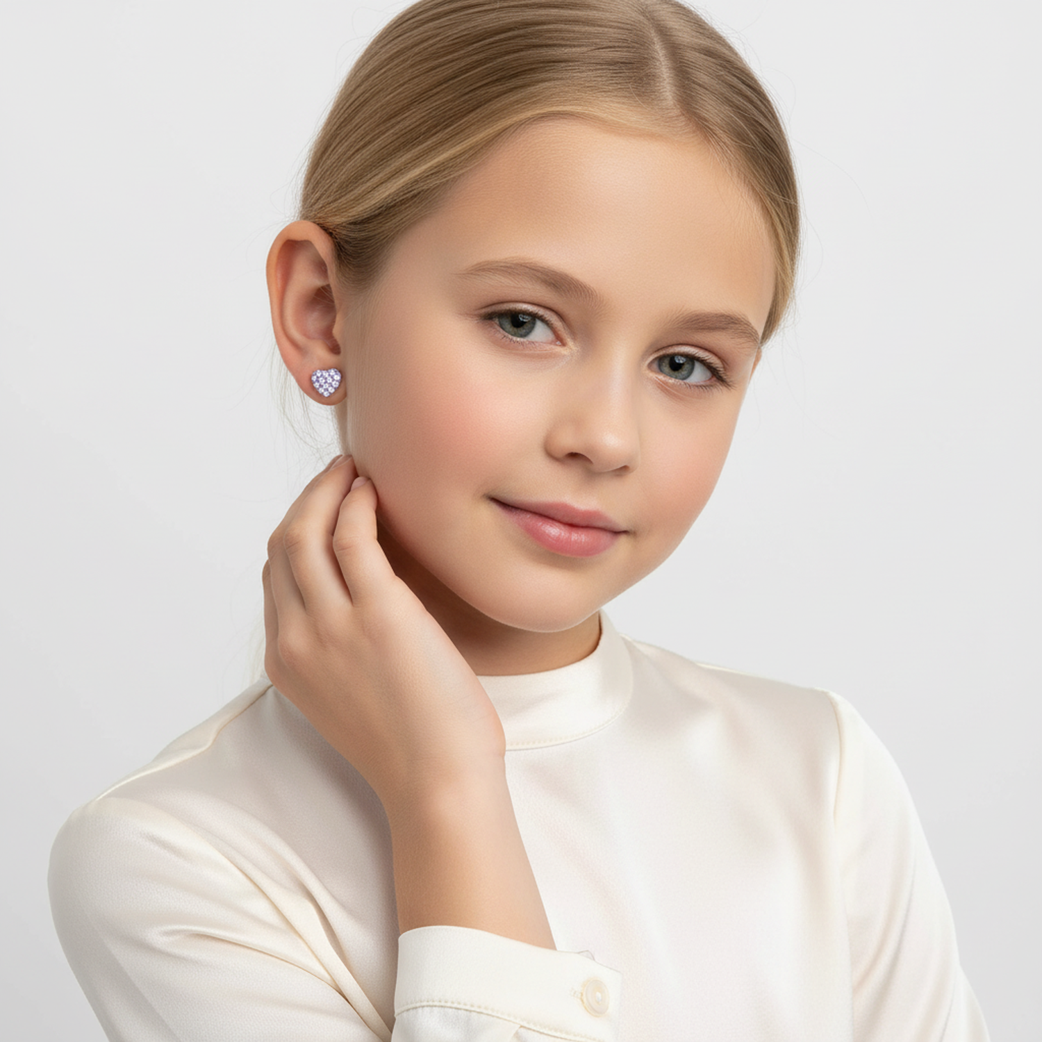 Young girl wearing lilac crystal stud earrings for kids by Melchior Jewellery against a plain background