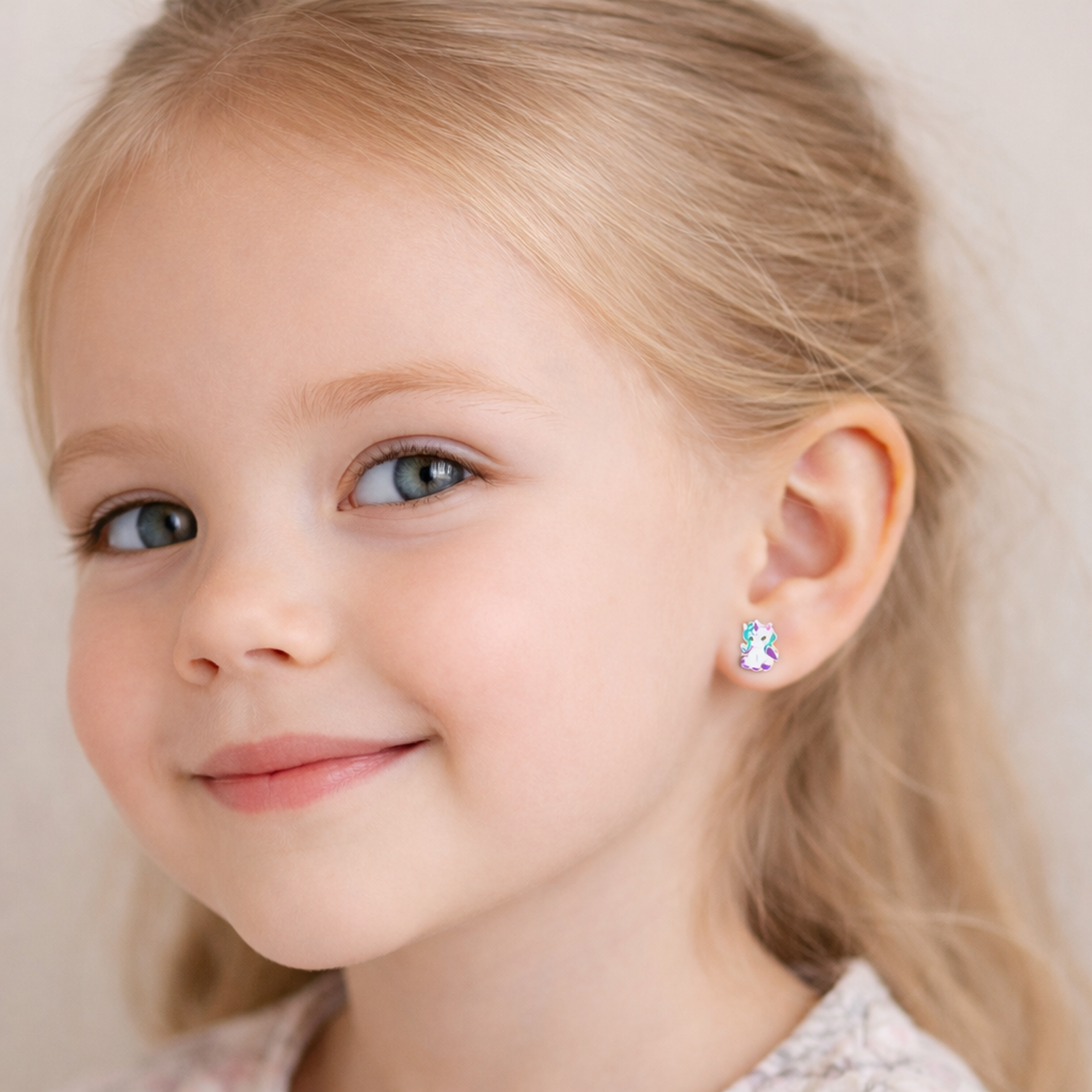 Little girl wearing Melchior Jewellery little girls unicorn studs childrens earrings with a smile