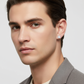 Mens 7mm silver earring worn by man with short dark hair and grey blazer in close-up portrait