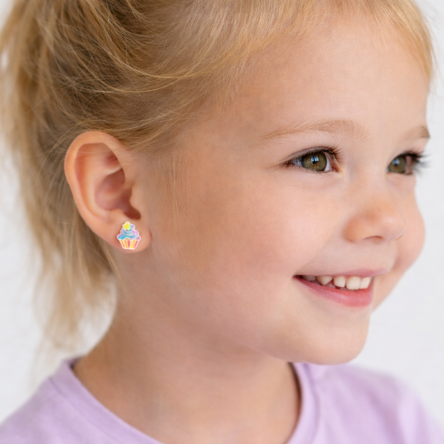 Melchior Jewellery multicolour kids cupcake stud earrings worn by a smiling child with blonde hair