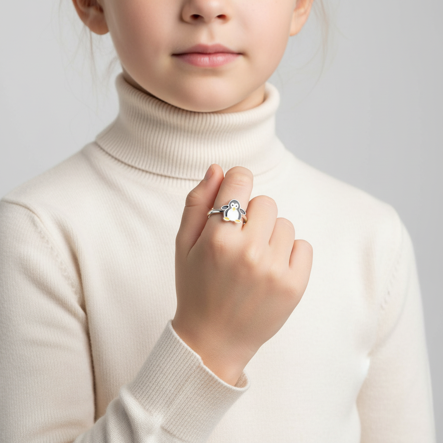 Child wearing Melchior Jewellery penguin themed silver ring featuring black and white enamel detailing