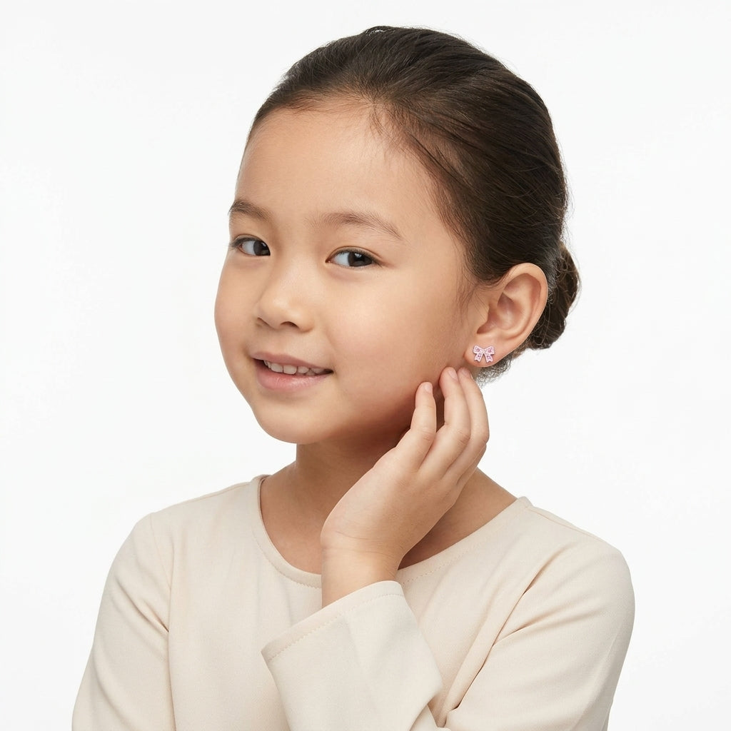Young girl wearing Melchior Jewellery pink crystal screw back earrings for girls shaped like bows