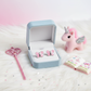 Pink glitter butterfly stud earrings for kids displayed in a blue jewellery box with toy unicorn and fairy wand