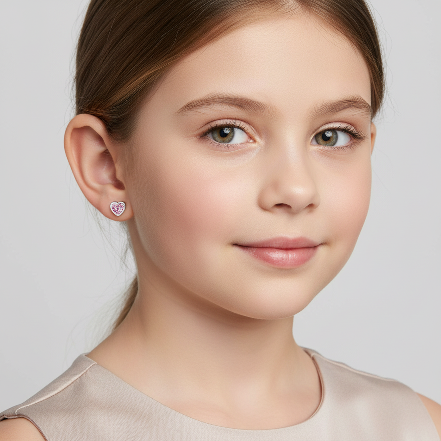 Girl wearing Melchior Jewellery pink heart earrings for girls with a delicate silver setting