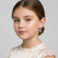 Young girl wearing pink open heart hoop earrings for girls by Melchior Jewellery in white blouse