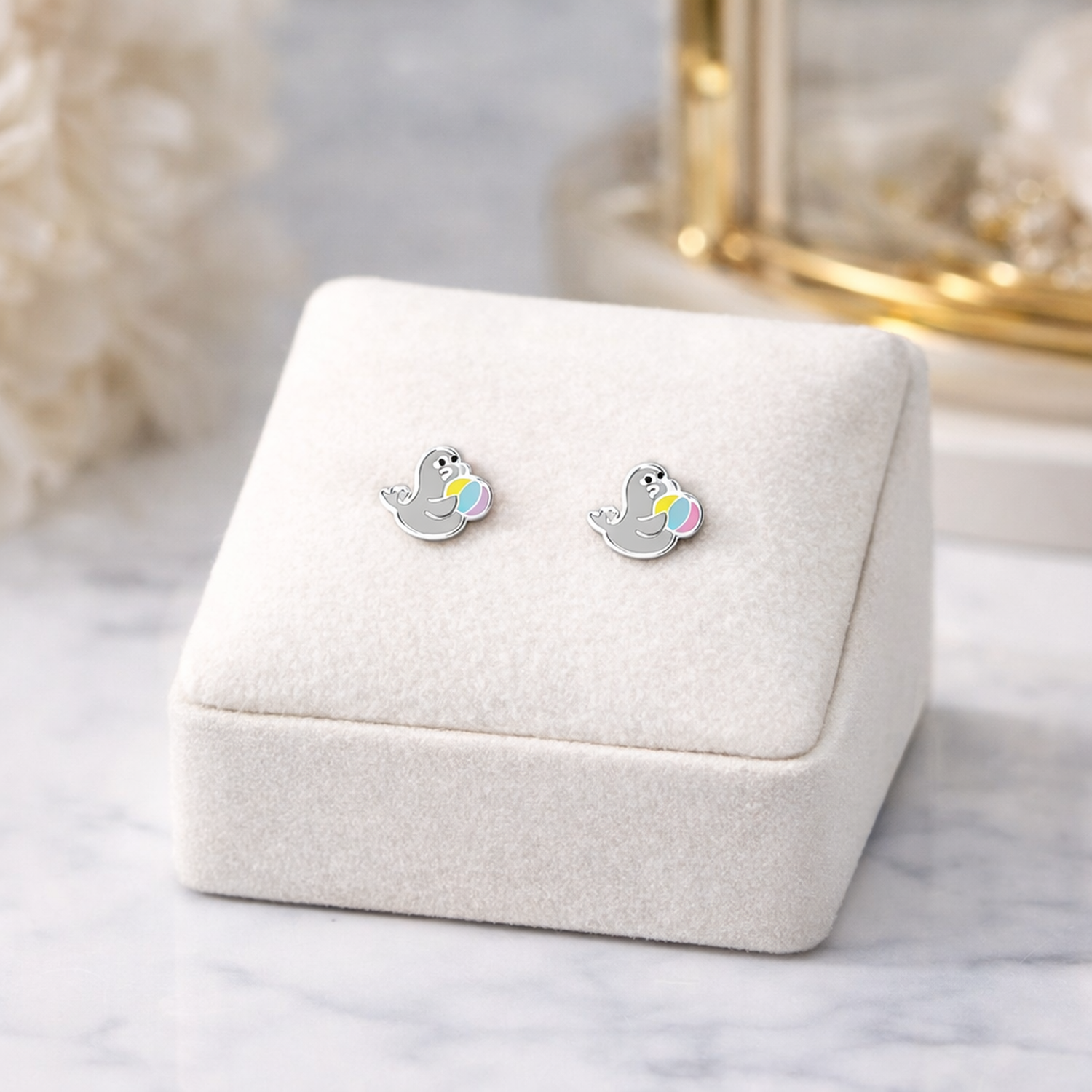 Seal stud earrings for girls by Melchior Jewellery on soft white display stand for children