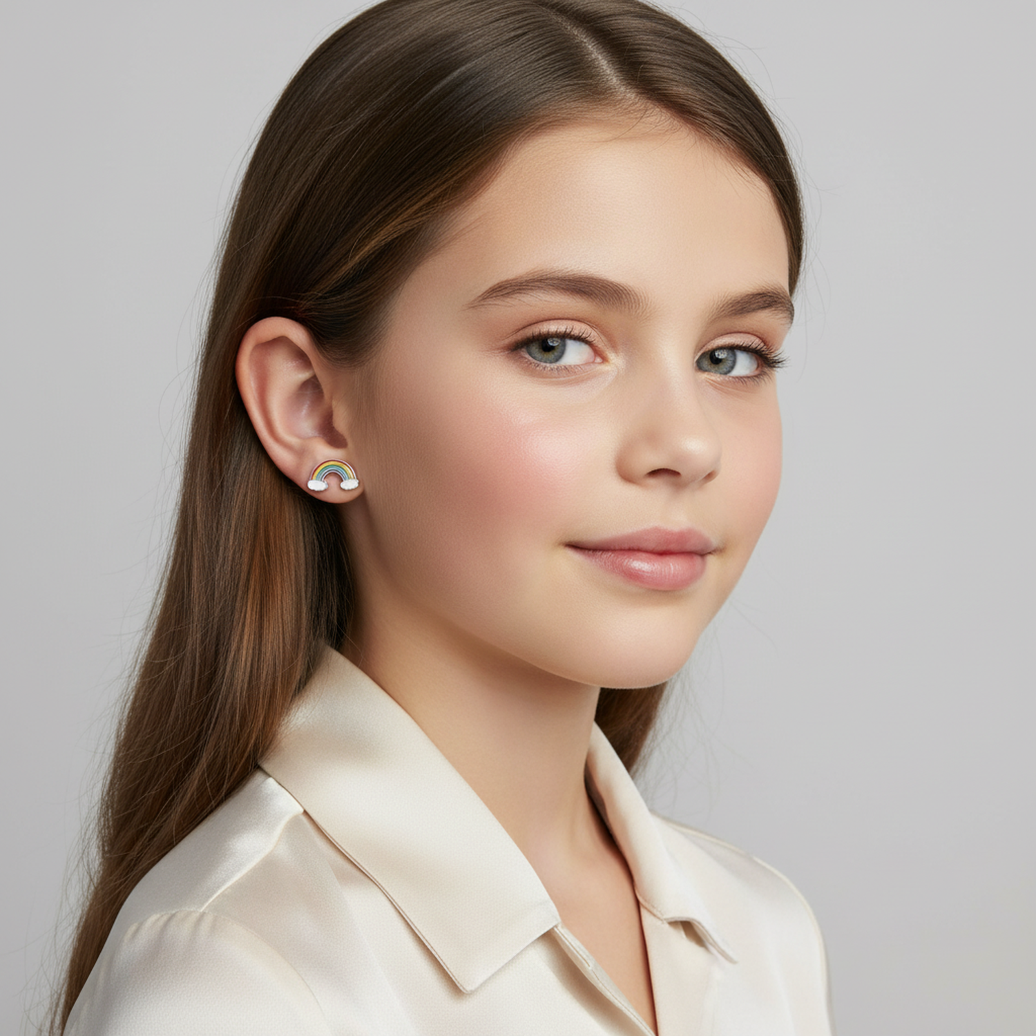 Young girl wearing silver rainbow earrings for girls by Melchior Jewellery with colourful enamel detail
