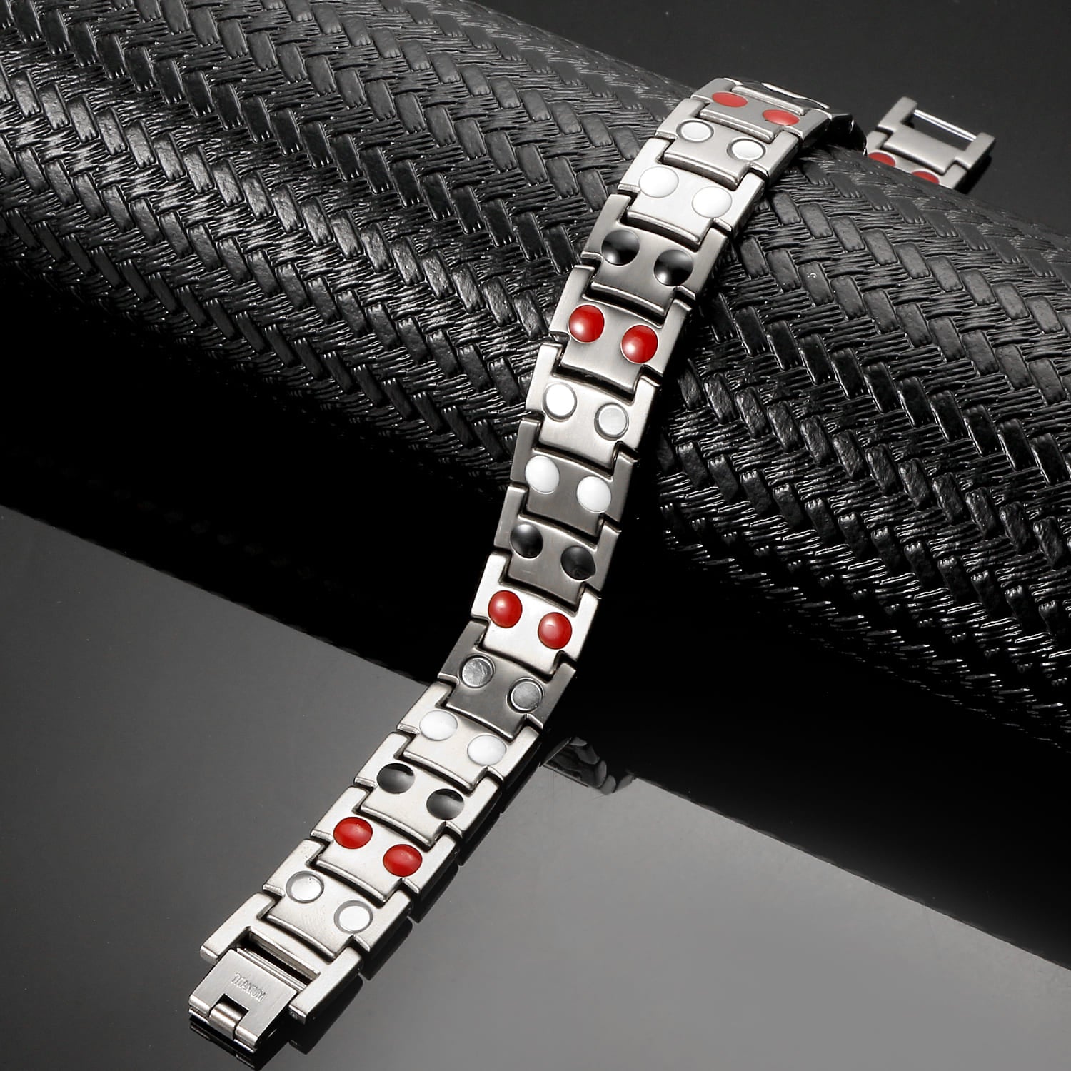 Melchior Jewellery silver titanium magnetic bracelet with red and white accents displayed on textured black background