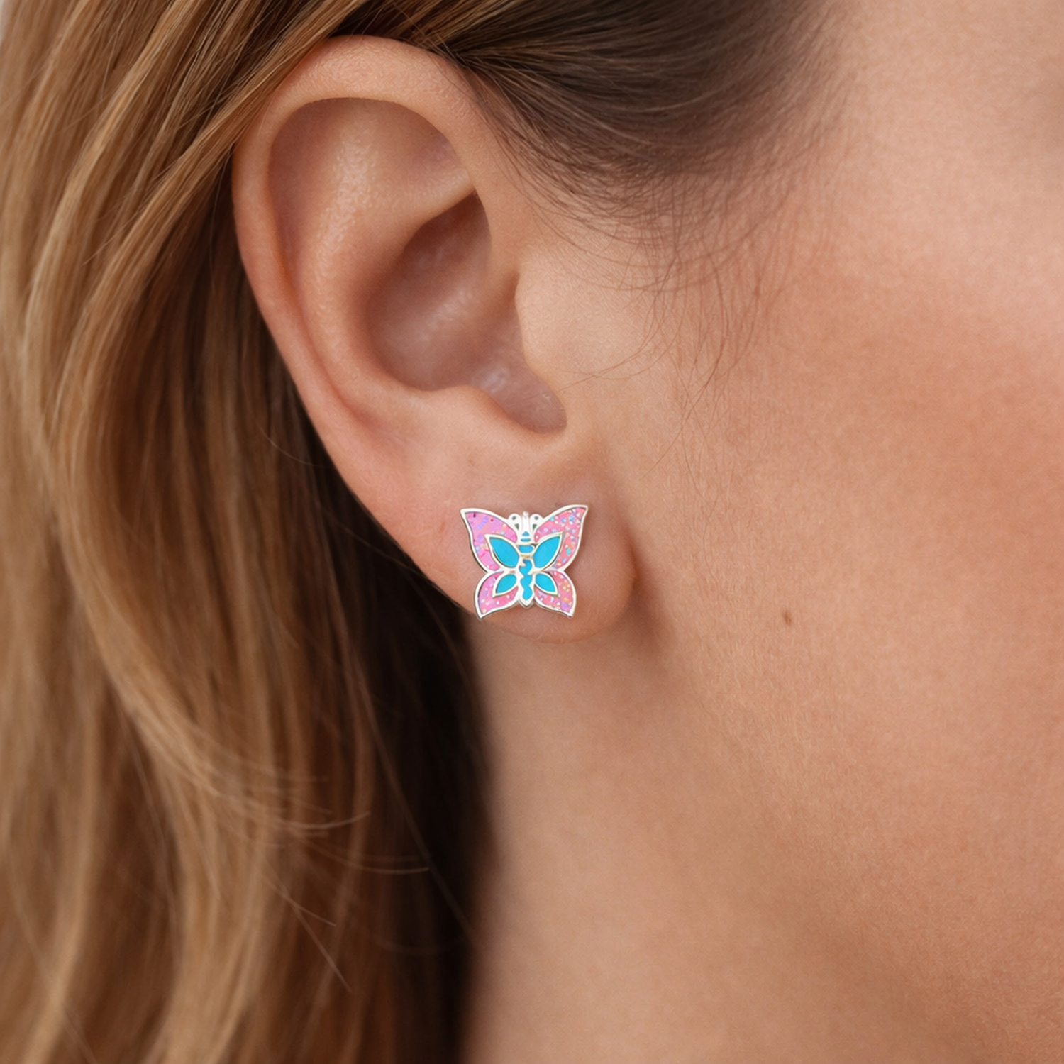 Melchior Jewellery sparkly butterfly stud earrings for kids worn on ear with pink and blue enamel details