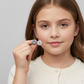 Girl holding sterling silver 7mm daisy earrings for girls by Melchior Jewellery close to her face