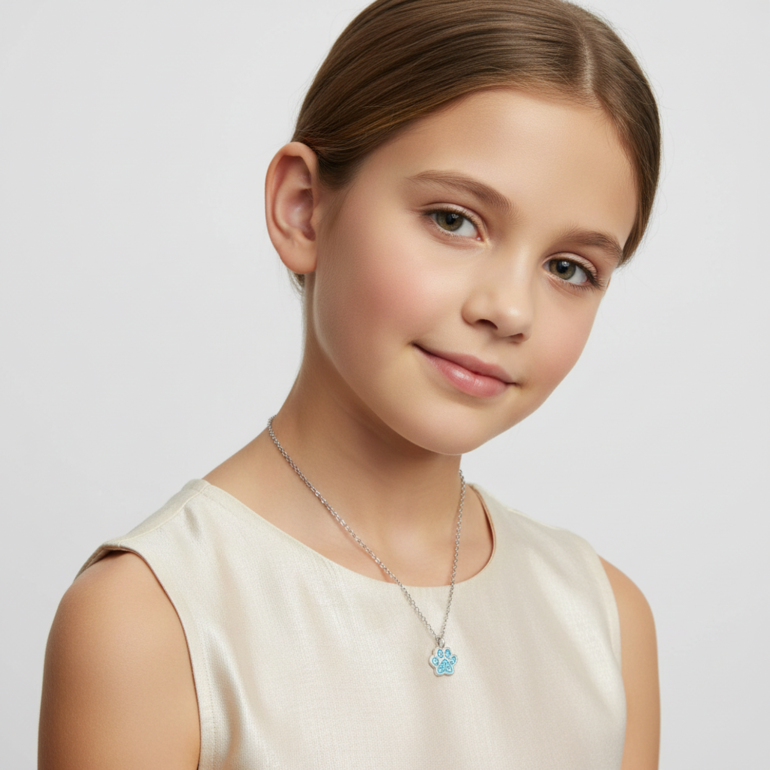 Child wearing Melchior Jewellery sterling silver animal pendant for children with blue paw design
