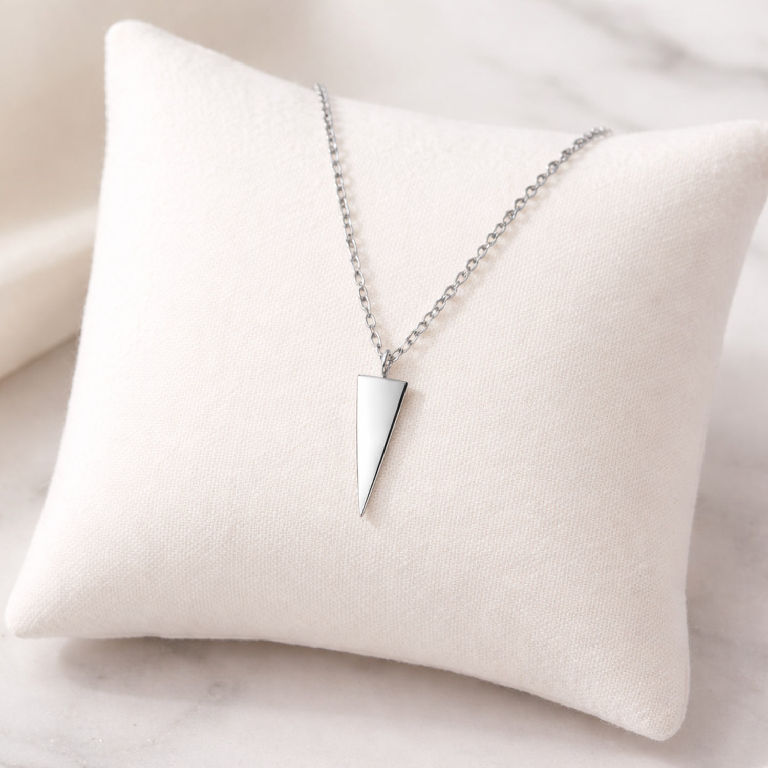 Sterling Silver Apex Spike Necklace displayed on a white cushion by Melchior Jewellery