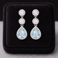 Sterling Silver Aquamarine Halo Drop Earrings by Melchior Jewellery displayed on black velvet